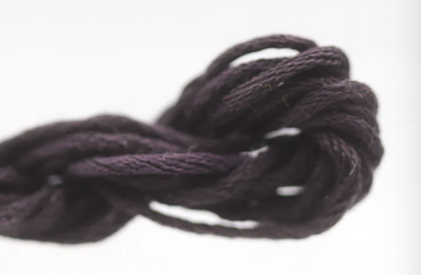 Close-up of a ball of dark yarn on a white background