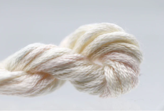 White skein of yarn on a light gray background