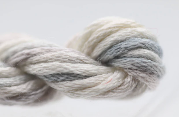 Ball of gray and white yarn on a light background