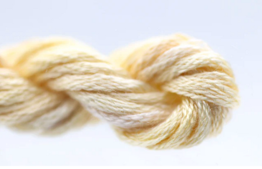 Close-up of a skein of cream-colored yarn on a light gray background