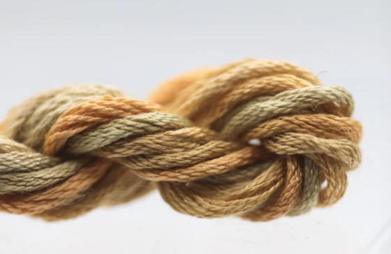 Coiled skein of brown and beige yarn on a light background