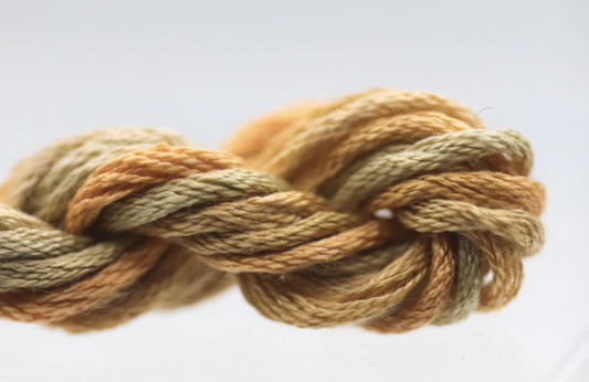 Coiled skein of brown and beige yarn on a light background