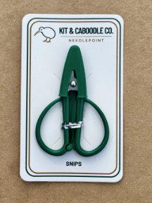 Green snips on a white card with branding, on a brown background