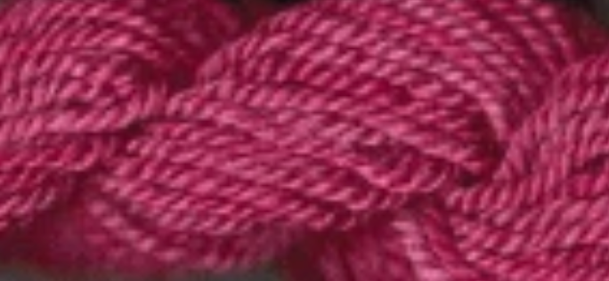 A close-up of twisted yarn in a deep berry pink color, filling the entire frame.