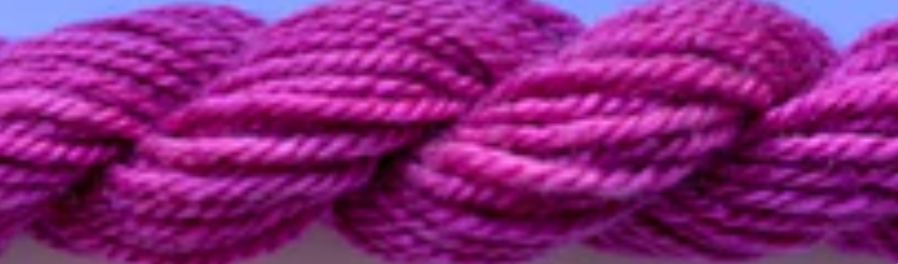A close-up of a thick, twisted skein of magenta-purple yarn showing its texture and color.