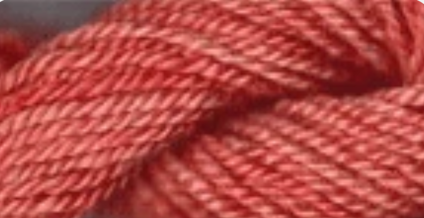 A close-up of twisted yarn or thread in a warm coral-red or salmon pink color, filling the frame.