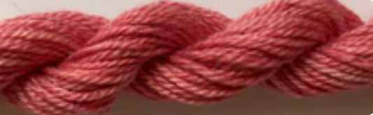 A close-up of a twisted yarn or wool skein in a dusty rose pink color