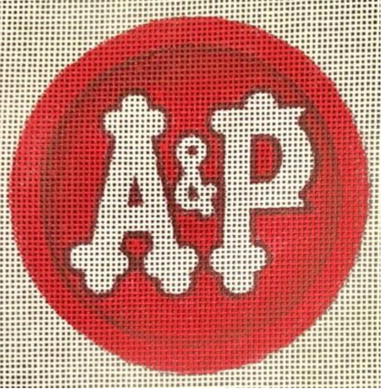 Red circular patch with white decorative lettering and ampersand