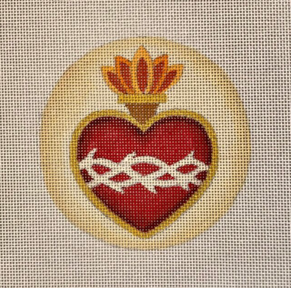 Red heart with golden crown and white ribbon on needlepoint canvas