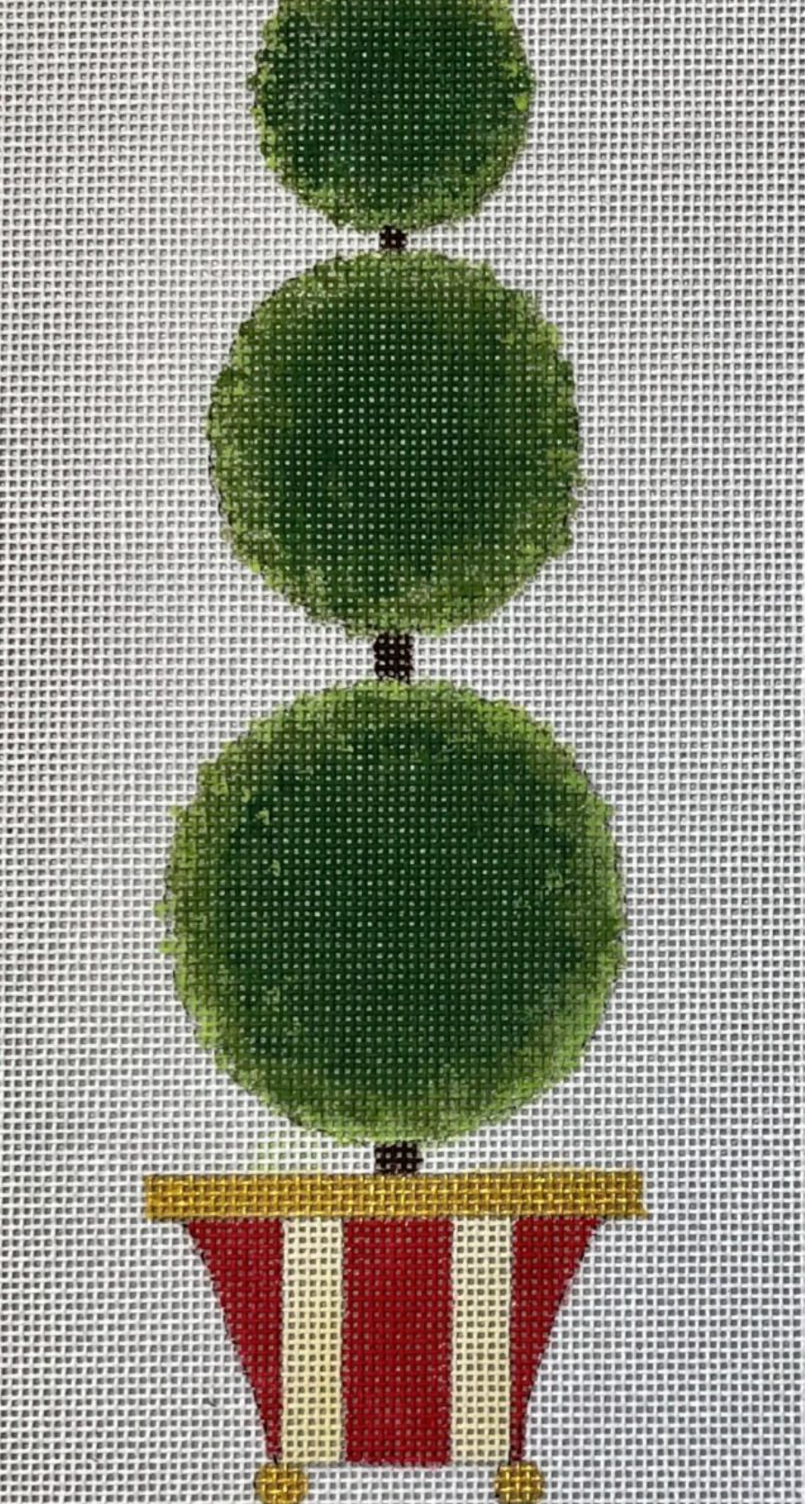 Green topiary tree with three round balls in striped pot