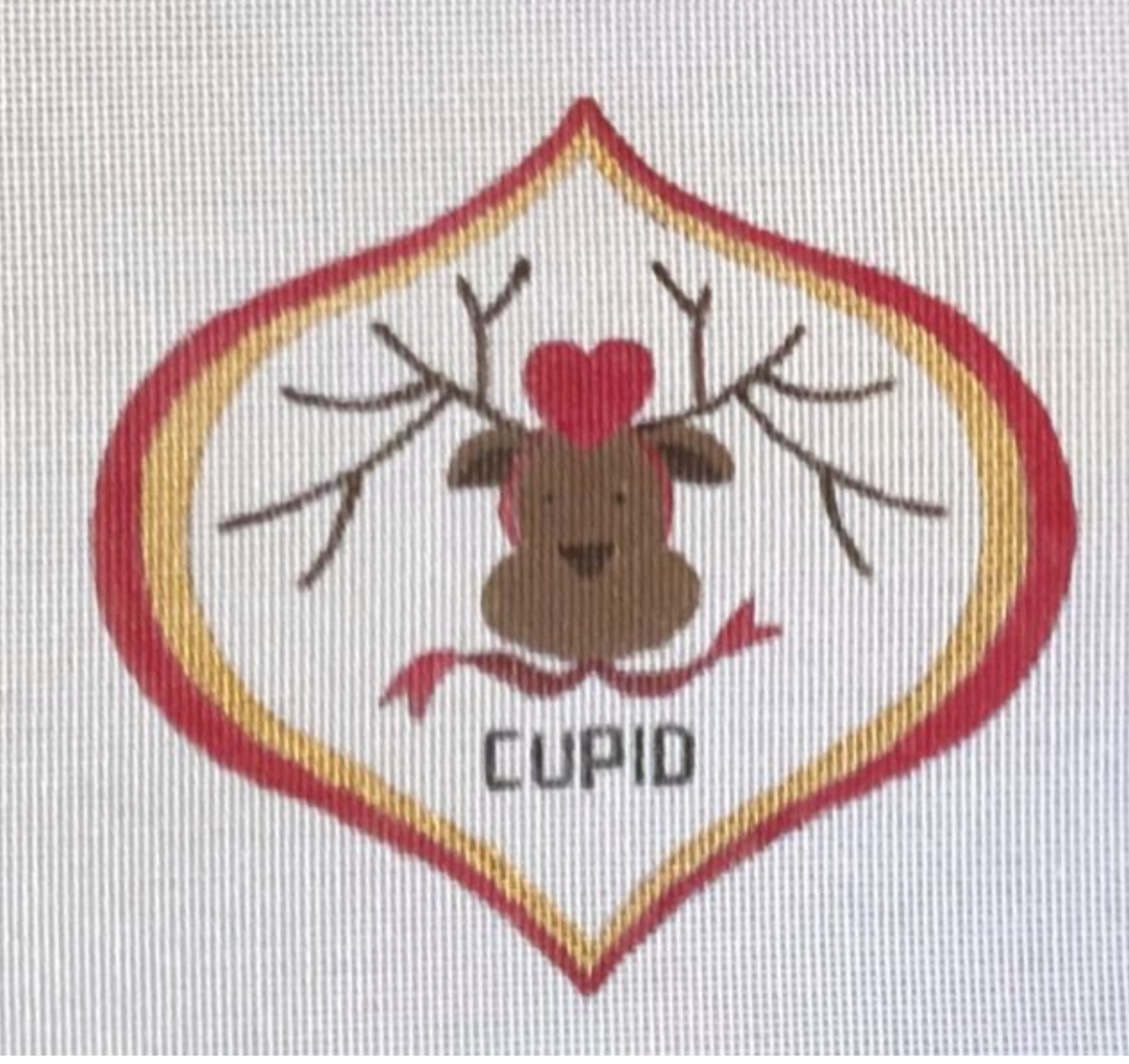 A reindeer needlepoint patch with a red heart nose and CUPID lettering