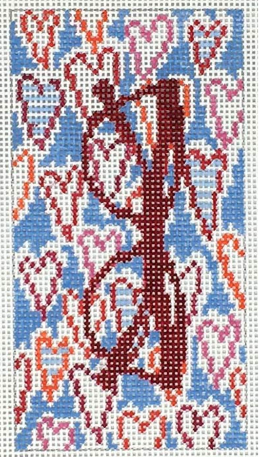 Dark red eyeglasses on a heart-patterned needlepoint canvas