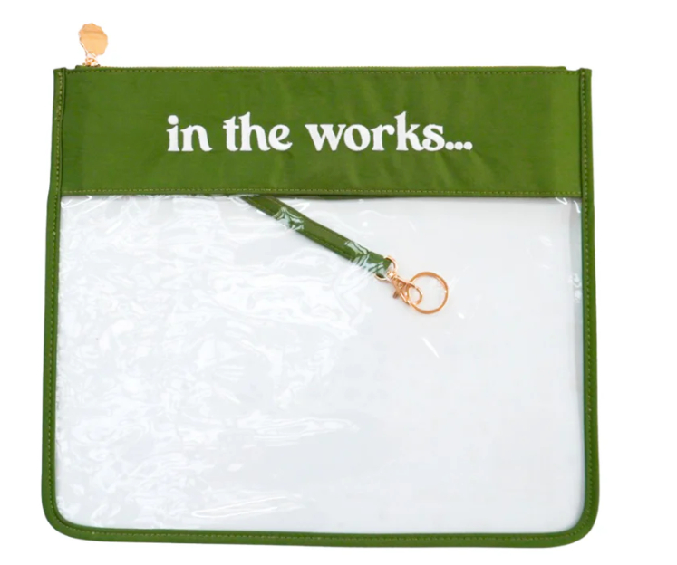 Green pouch with 'in the works...' text and clear interior filled with bubble wrap.