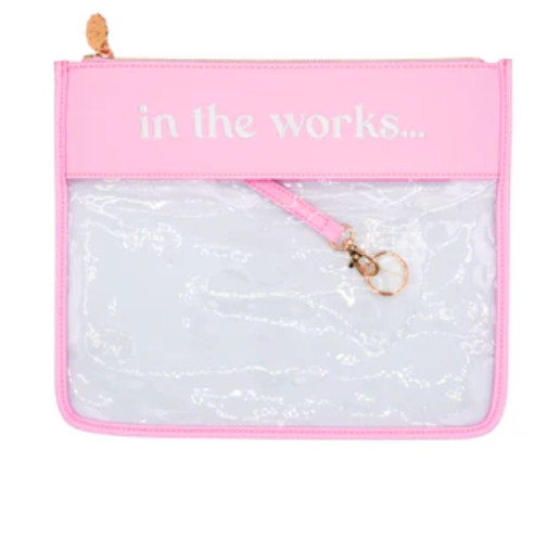 Pink pouch with 'in the works...' text and clear pouch inside on a white background